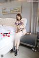 a woman sitting on top of a bed next to a dresser