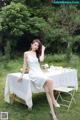 A woman in a white dress sitting at a table.