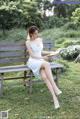 A woman sitting on a bench reading a book.