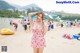 A woman in a pink bathing suit standing on a beach.