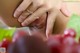 A close up of a person touching a bunch of grapes.