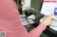 A woman using a smartphone to pay with a credit card machine.