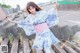 A woman in a blue and white kimono is standing on some steps.