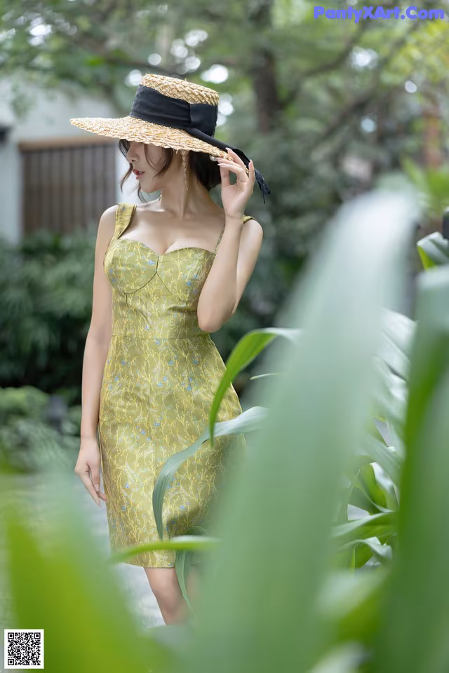 A woman in a yellow dress and a straw hat.