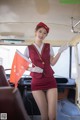 A woman in a red uniform holding a red flag.