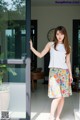 A woman standing in front of a glass door.