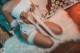 A woman in a white lingerie sitting on a white rug.