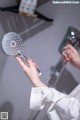 A woman is holding a shower head in her hand.