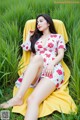 A woman sitting on a yellow chair in a field.