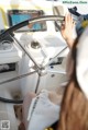 A woman sitting at the helm of a boat with her hand on the steering wheel.