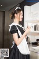 A woman in a maid outfit holding a cup of coffee.