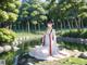 A woman in a white dress sitting on a rock by a river.