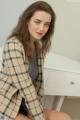 A woman sitting on top of a white desk.