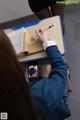 A woman sitting at a desk writing in a book.