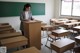 A woman standing at a podium in a classroom.