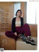 A woman sitting on top of a bathtub in a bathroom.