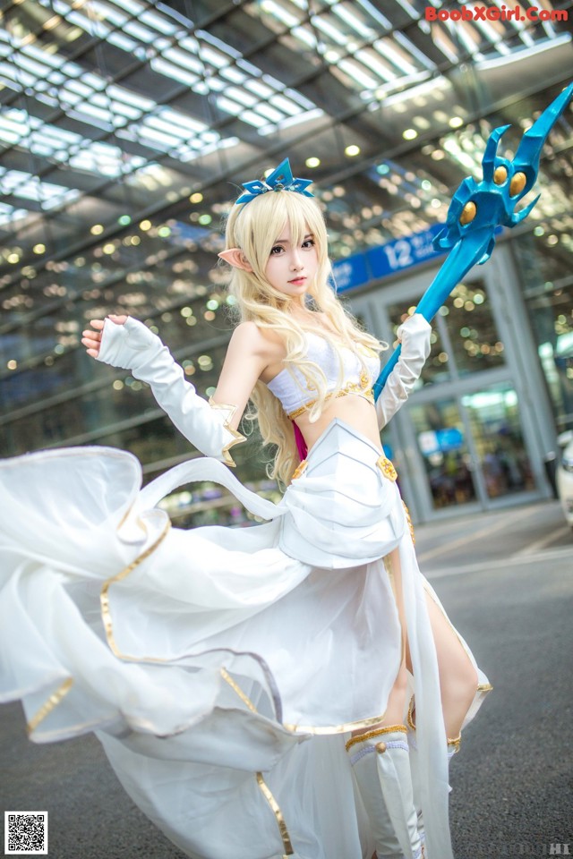 A woman in a white dress holding a blue sword.