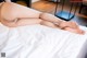 A woman laying on top of a bed with her legs crossed.