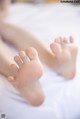 A close up of a person's feet on a bed.